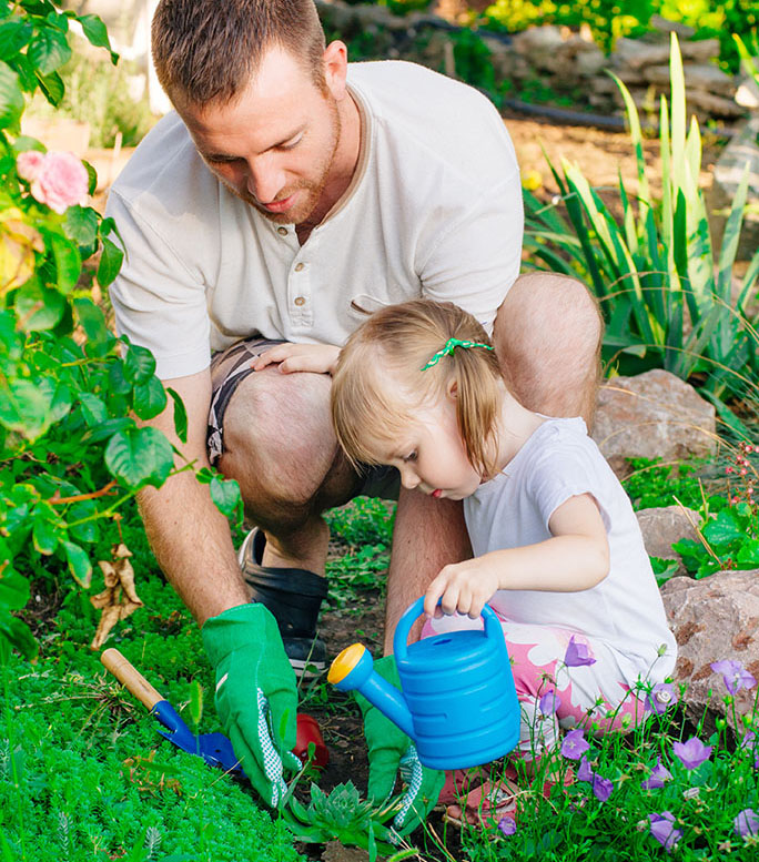 A man and a toddler planting flowers